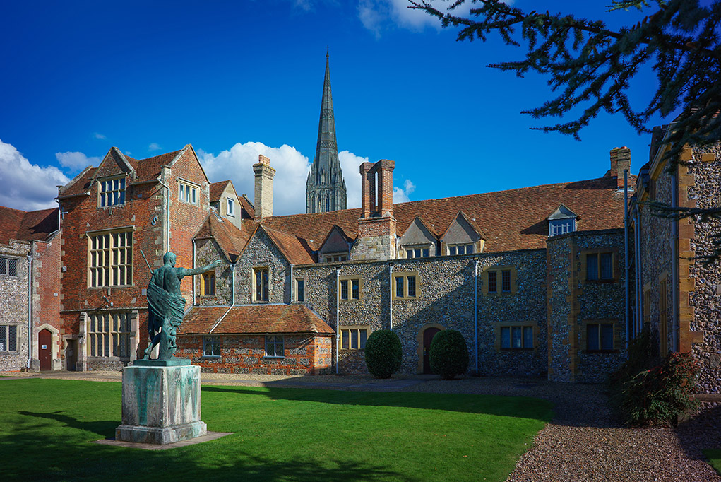 Wide view of old buildings with a spire behind