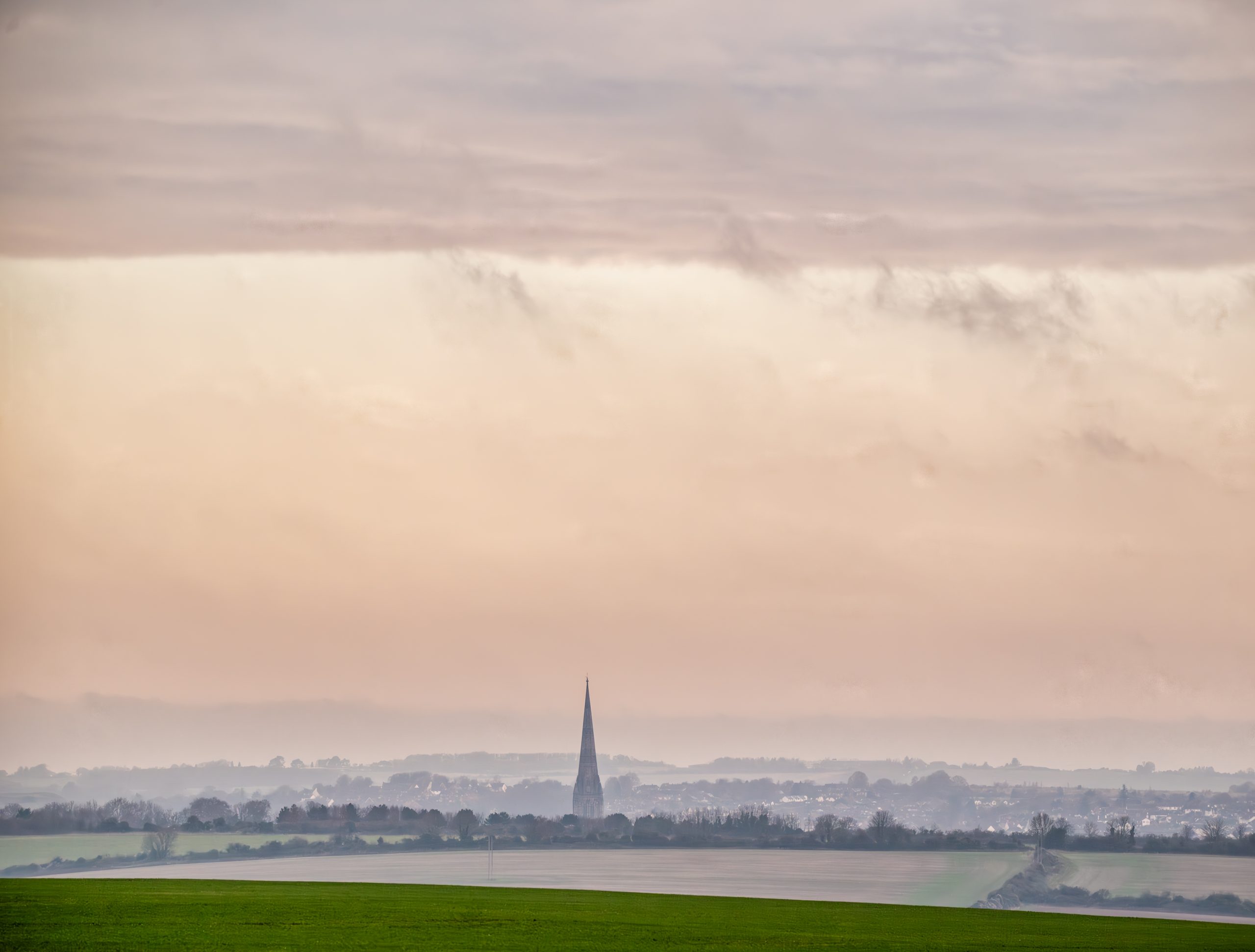 Cathedral spire amongst the cityscape, seen in the mist from a distance