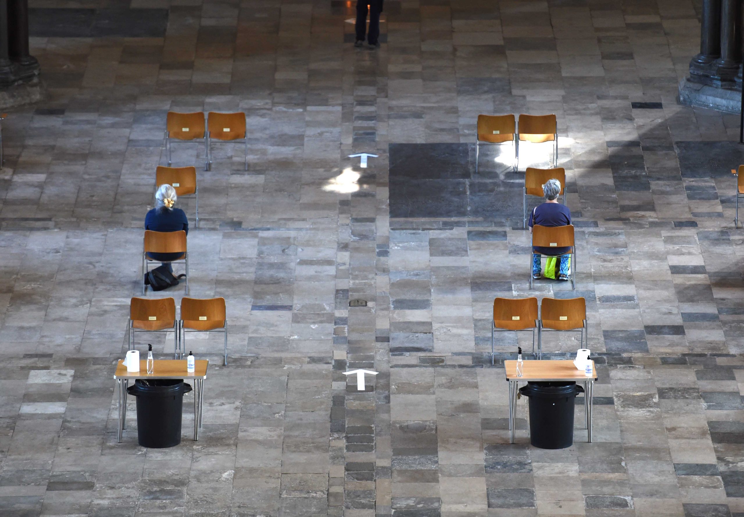 Worshippers sat apart from eachother in the nave with social distancing signs on the floor