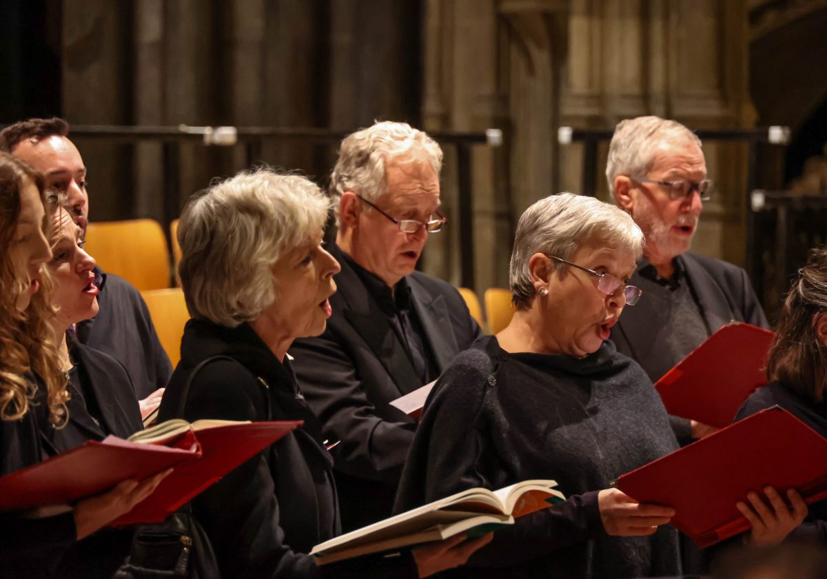 A mixed group of choir members singing inside the Cathedral